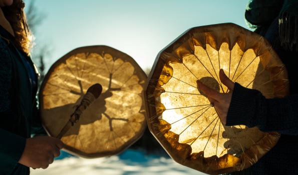 Two people holding drums in their hands with drum beaters