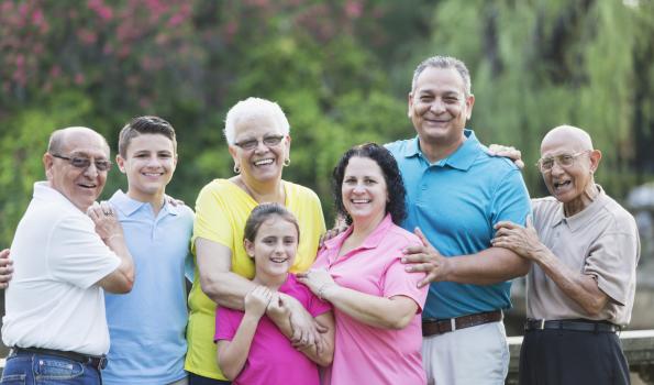 A group of happy, smiling people posing for a picture in different colored shirts