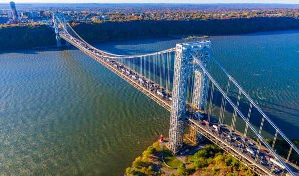 A picture of a bridge over water with cars traveling over it