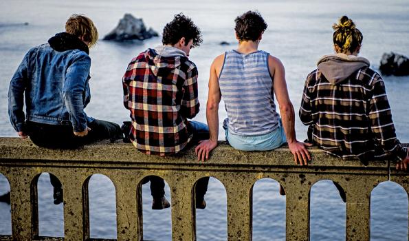 Photo of Four Young Adults, Sitting on a Pier -Photo by Sammie Vasquez